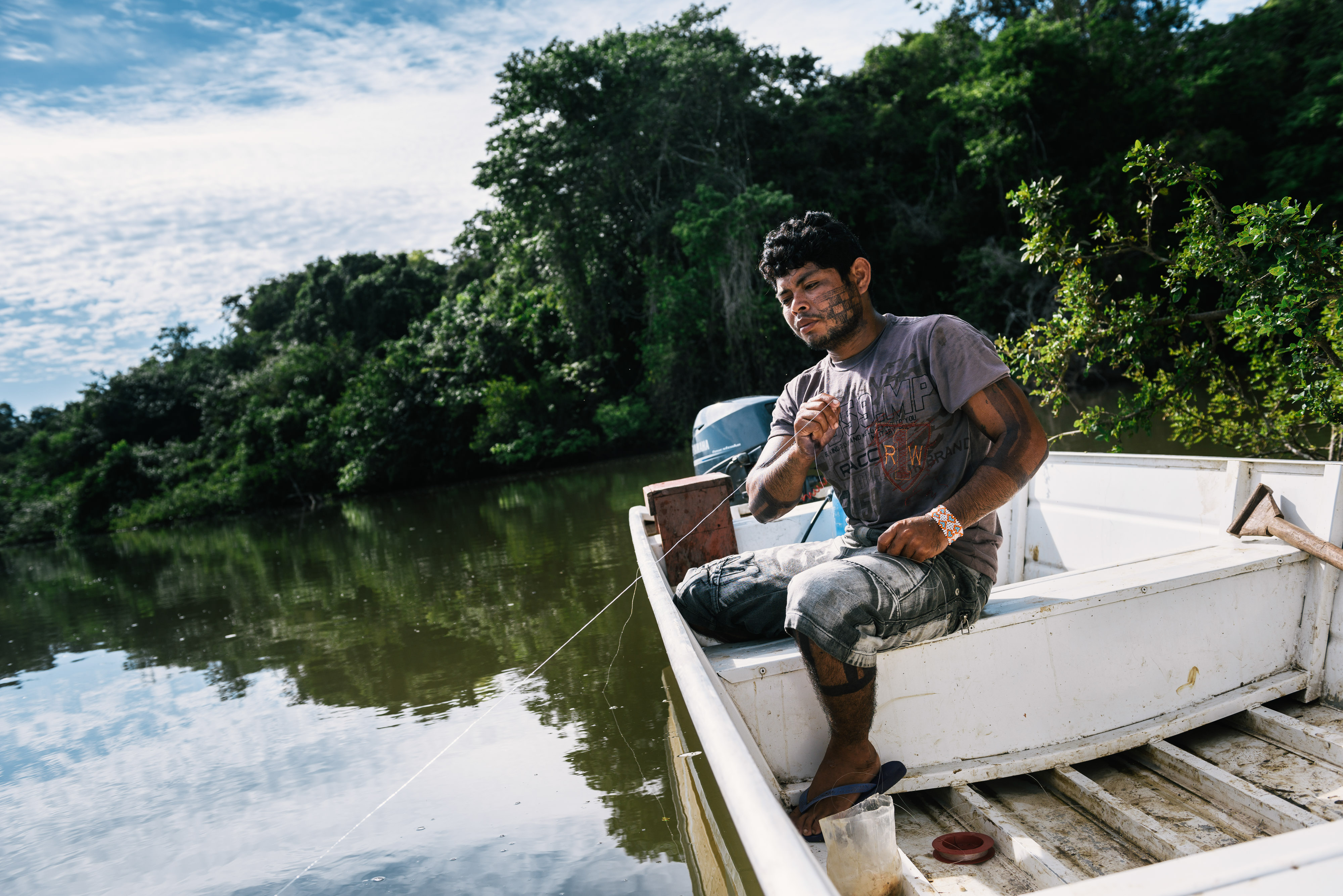 Indígena pescando em barco
